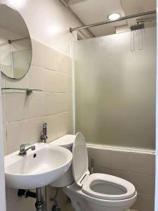 ein Badezimmer mit einer weißen Toilette und einem Waschbecken in der Unterkunft City Land Tagaytay Prime in Ulot + 3 Fotos