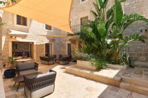een patio met stoelen, tafels en planten bij Central Heritage Hotel in Split