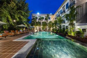a swimming pool in front of a building at night at Green Amazon Residence in Siem Reap +159 photos