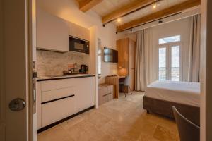 a bedroom with a bed and a kitchen in a room at V60 Valletta in Valletta