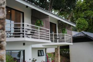 a white house with white balconies and trees at B89 3BR Hillside Seaview Escape in Ban Ko Kok