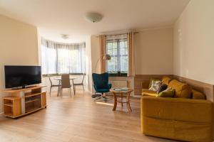 a living room with a couch and a tv and a table at Apartament Słoneczny by Grand Apartments in Sopot