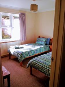 a room with two beds and a window at Bungalow in Cambridge- 3 bedrooms in CBG