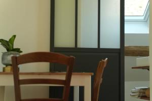 una mesa de comedor con 2 sillas y una mesa con una planta en Studio de charme, en Achères-la-Forêt 7 fotos más