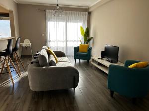 a living room with a couch and a tv at The Lighthouse Apartment in Praia da Barra