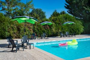 a swimming pool with chairs and umbrellas and a pool toy at Domaine de Sainte-Croix in Sainte-Croix