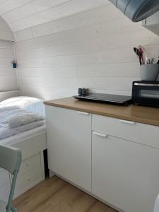 ein Zimmer mit einem Bett und einem Schreibtisch mit einem Laptop darauf in der Unterkunft Bauwagen in Fanø