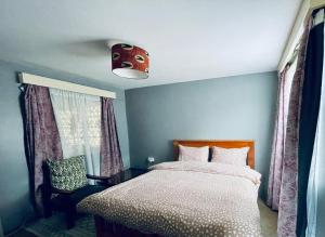 a bedroom with a bed and a large window at Neitu Shalom Nest in Eldoret