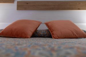 two orange pillows sitting on a bed at Vivienda rural La Puentezuela in Grazalema