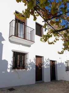 ein weißes Gebäude mit Fenstern und einem Balkon in der Unterkunft Vivienda rural La Puentezuela in Grazalema