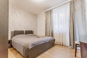a bedroom with a bed and a large window at APARTAMENT de LUX SIBIU in Sibiu