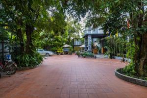 a brick walkway with trees in front of a building at Green Amazon Residence in Siem Reap