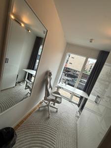 a room with a mirror and a chair in front of a window at Bright and inviting apartment in Frederiksberg in Copenhagen +2 photos