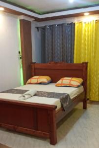 a bedroom with a wooden bed with two pillows at Royal properties thika jomoko in Thika