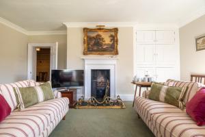 a living room with two couches and a fireplace at Hopton Court Apartment in Hopton Wafers