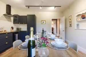a kitchen and dining room with a table with wine bottles at Hopton Court Apartment in Hopton Wafers