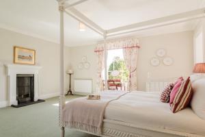 a white bedroom with a bed and a fireplace at Hopton Court Apartment in Hopton Wafers