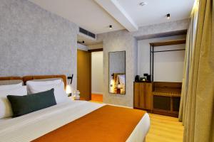 a bedroom with a large bed and a mirror at Acropolis Grid Athens in Athens