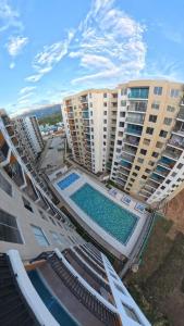 Una vista aérea de edificios de apartamentos con piscina. en APARTAMENTO FAMIliar MELGAR, en Melgar