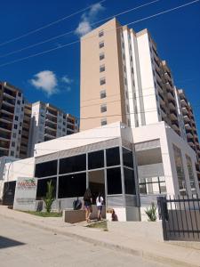 dos personas caminando frente a un edificio en APARTAMENTO FAMIliar MELGAR, en Melgar