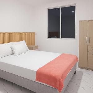 Un dormitorio con una cama grande y una ventana en APARTAMENTO FAMIliar MELGAR, en Melgar