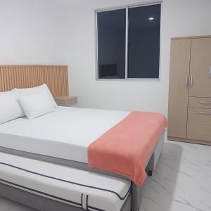 Un dormitorio con una cama y un armario de madera. en APARTAMENTO FAMIliar MELGAR, en Melgar 4 fotos más