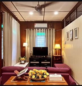 a living room with a purple couch and a tv at Cinta Abadi Resort in Bidur