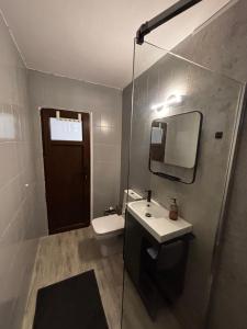 a bathroom with a toilet and a sink and a mirror at RENTeaza Studio IOR Park in Bucharest +7 photos