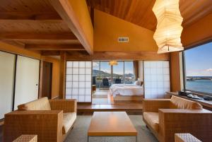 a room with a bedroom and a bed with a view at 萩八景 雁嶋別荘 in Hagi