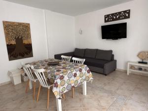 una sala de estar con una mesa y un sofá en Vivienda Vacacional Casa Ola, en Ajuy