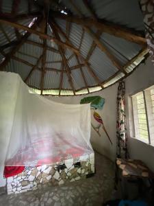 a room with a bed with a mosquito net at Jallo Kurundingoto Eco Tourist Camp in Nyofelleh