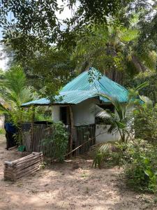 a small house with a blue tin roof at Jallo Kurundingoto Eco Tourist Camp in Nyofelleh +7 photos