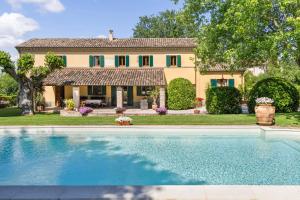 een huis met een zwembad voor een huis bij Villa Delle Vigne in Novilara