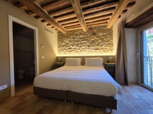 AlleronaにあるSix Keys Guesthouseの石壁のベッドルーム1室(大型ベッド1台付)