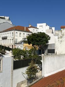 a view of a city with white buildings and trees at Inglesinhas in Lisbon