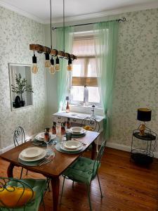 a dining room with a wooden table and green chairs at Aquavinum in Niederdorla