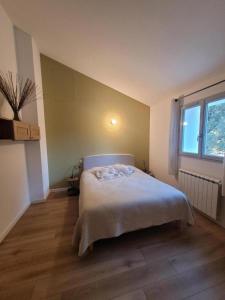 une chambre avec un lit et une fenêtre dans l'établissement La chouette paisible, à Villecroze