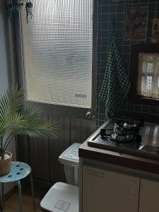 Una cocina con estufa y fregadero. en 들락스테이 Deullak Stay, en Millak-tong