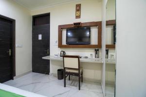 a room with a chair and a tv on a wall at Hotel Rockland & Restaurant in Jaipur +17 photos