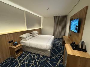 a hotel room with a bed and a flat screen tv at فندق كرم مضياف Karam Medyaf Hotel in Al Khansāk