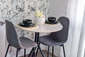 a table with two chairs and two cups and a vase at Views From The 214 in Johannesburg