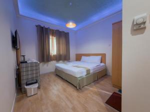 a bedroom with a bed and a blue ceiling at Sama Hotel in Sharjah