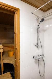 a shower in a bathroom with white tiles at Liam's Villa in Rovaniemi +16 photos