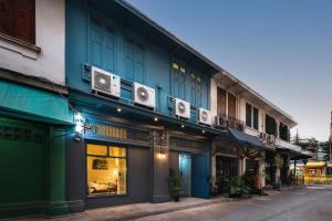 a blue building with speakers on the side of it at Non Inn Entire Historic 5 Bedroom Riverside Shophouse near ICONSIAM for Families and Groups in Bang Rak