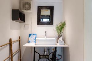 a bathroom with a sink and a mirror at Non Inn Entire Historic 5 Bedroom Riverside Shophouse near ICONSIAM for Families and Groups in Bang Rak +51 photos