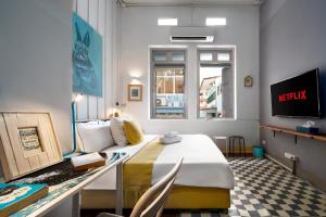 a hotel room with a bed and a desk at Non Inn Entire Historic 5 Bedroom Riverside Shophouse near ICONSIAM for Families and Groups in Bang Rak