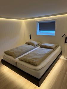 Un dormitorio con una cama grande con ventana. en Arctic apartment Tønsvik, en Tromsø