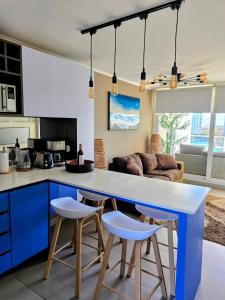 a kitchen with a large white counter and blue cabinets at Serena's Beach Apartment in La Serena