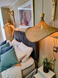 a room with a bed with pillows and a lamp at Serena's Beach Apartment in La Serena