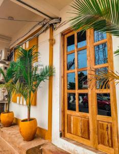 two palm trees in pots next to a door at De Dreams beach in Puducherry